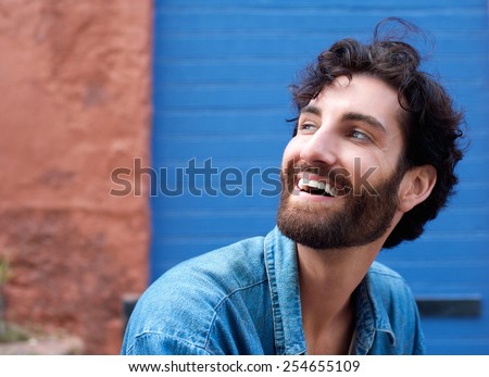 Close up portrait of an attractive man with beard laughing