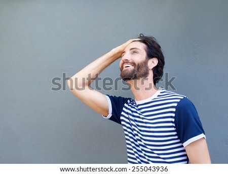 Close up portrait of a cool guy smiling with hand in hair