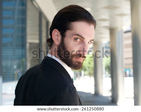 Close up portrait of a handsome businessman looking over shoulder