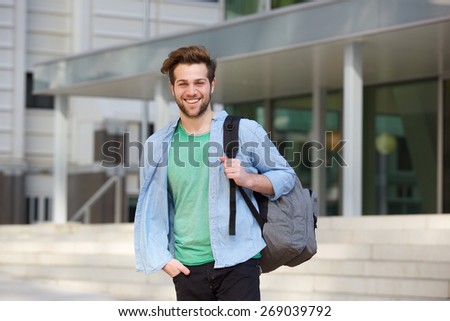 Portrait of a cheerful college student standing outside with back