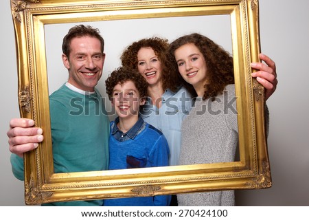 Portrait of a happy family holding picture frame and smiling