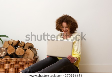 Portrait of a happy older woman using laptop oat home