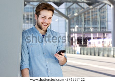 Close up portrait of a cool guy smiling with mobile phone
