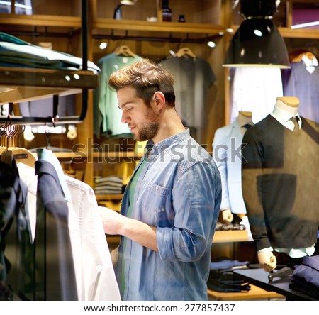 Portrait of a handsome young man shopping for clothes at shop