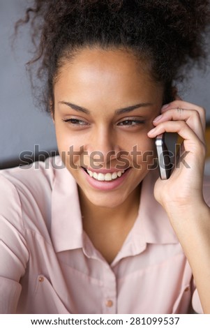Close up portrait of a smiling black woman talking on cell phone