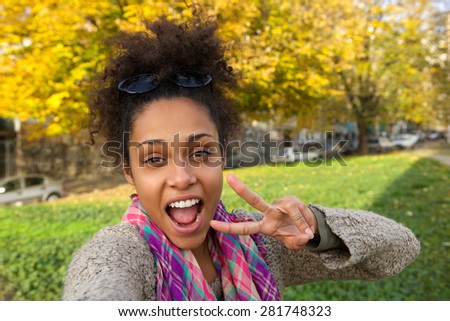 Selfie portrait of a happy woman with showing peace sign