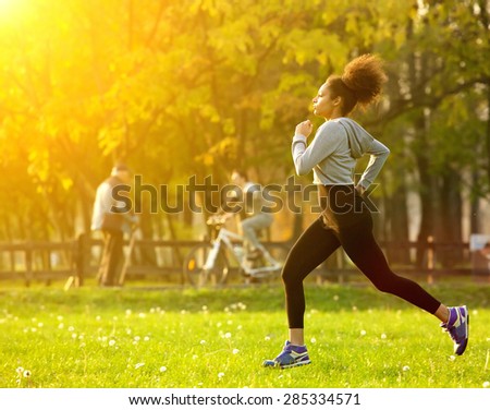 Full body portrait of an african american woman running outdoors