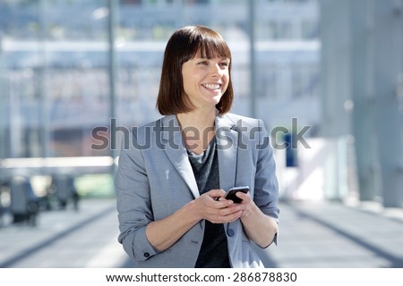 Close up portrait of a smiling business woman walking with cell phone