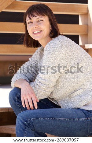 Portrait of a smiling older attractive woman sitting outside