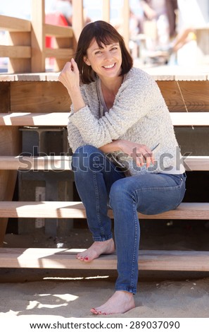 Portrait of an attractive happy woman sitting on steps outside