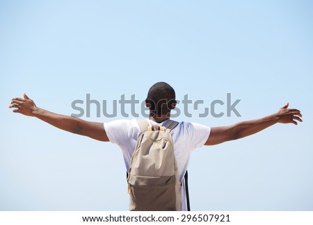 Young black man standing with arms outstretched from behind