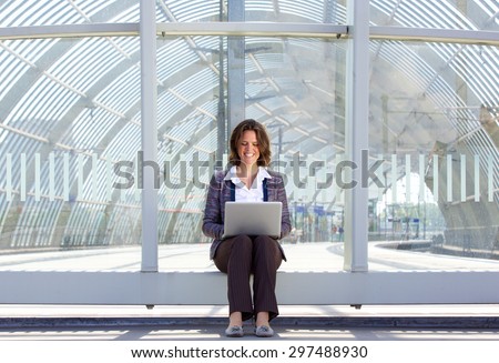 Portrait of a business woman sitting outside and looking at laptop