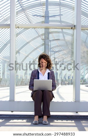 Portrait of a business woman sitting outside using laptop