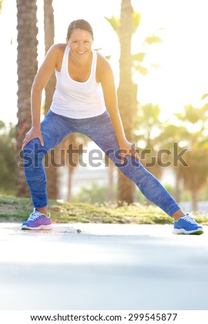 Portrait of a smiling older woman stretching muscles bending down