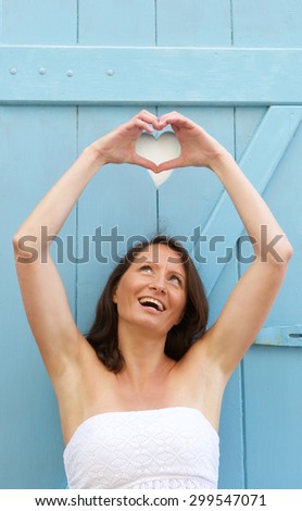 Portrait of a happy woman making heart shape with hands