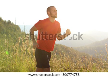 Portrait of a healthy sports man jogging outdoors in nature