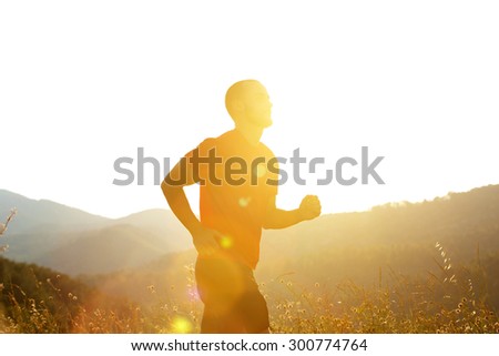 Silhouette of a man running outdoors with sunsetting behind him