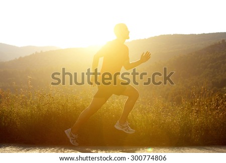 Side portrait of a man running outside with sunset