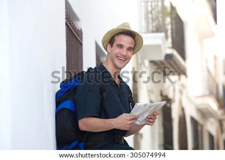 Portrait of a traveling man laughing outside with map