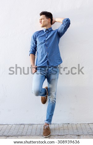 Full body portrait of an attractive male fashion model posing against white background