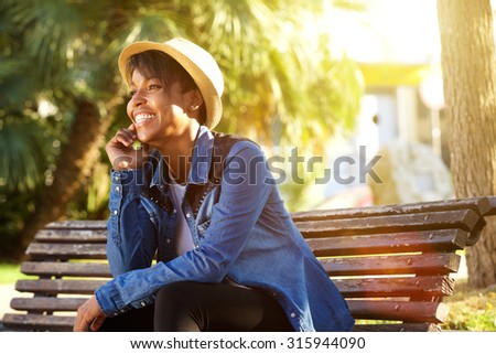 Portrait of a cheerful young african american woman sitting outside