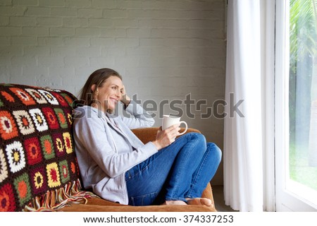 Portrait of a smiling older woman relaxing at home with cup of tea