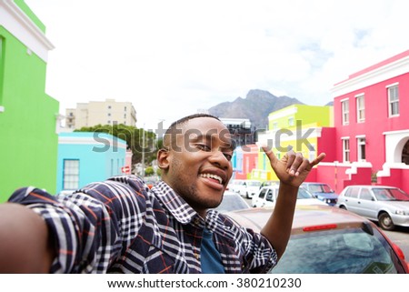 Close up portrait of cool young african guy taking a selfie while out on the city street
