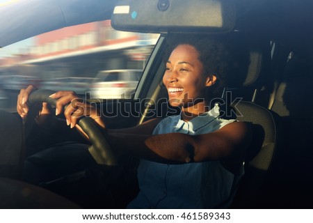 Portrait of smiling young african american woman driving a car