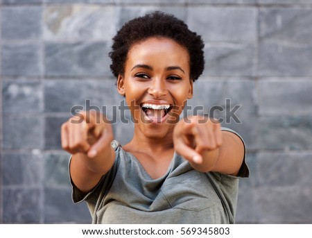 Portrait of attractive happy young black woman pointing fingers
