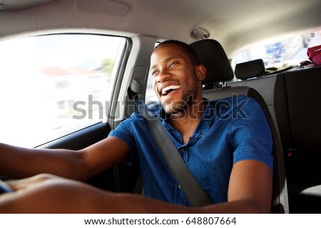 Portrait of happy young african man enjoying driving a car