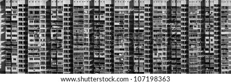 Black and white panoramic facade of a huge Eastern European residential building.