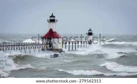 Lake Michigan Lighthouse in St Joe gets pounded during a massive wind storm and waves flow over the entire pier