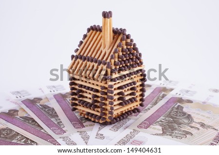 House made of matches is on a fan of banknotes