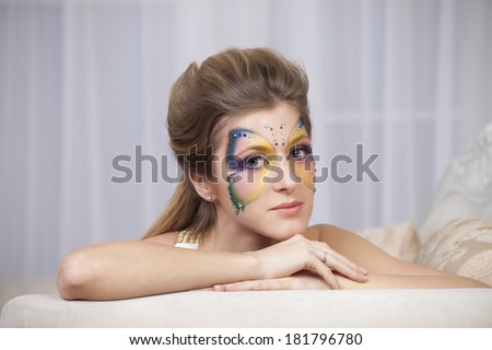 Portrait of beautiful girl with body art butterfly on her face