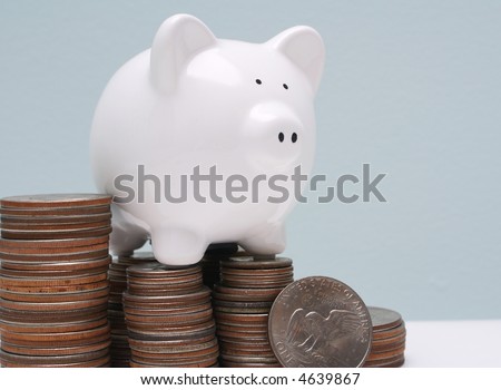 White piggy bank on stack of silver dollars