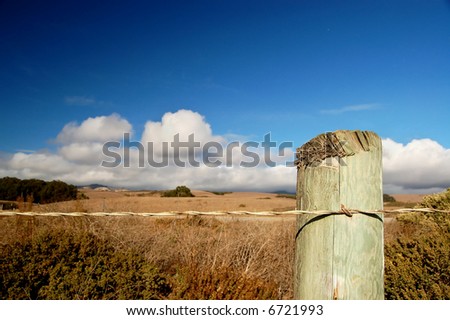 A roadside fence post under a blue sky along the Pacific Coastal Highway in California