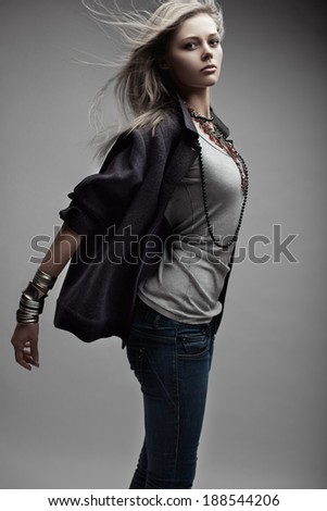 Fashion model with flying blonde hair jumping in studio. Magnificent hair.