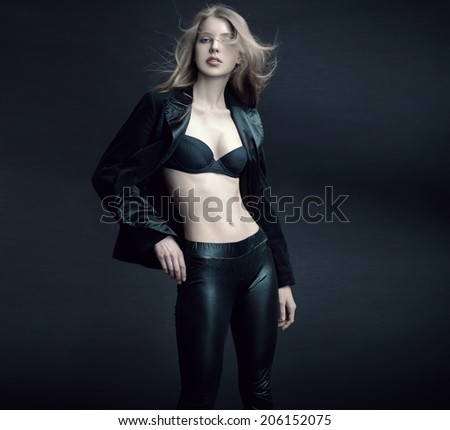 Fashion studio portrait of stunning blonde model with long windswept straight hair.