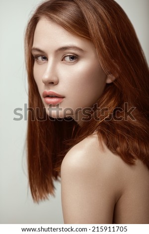 Beauty portrait of young sexy red-haired model with long straight hair.