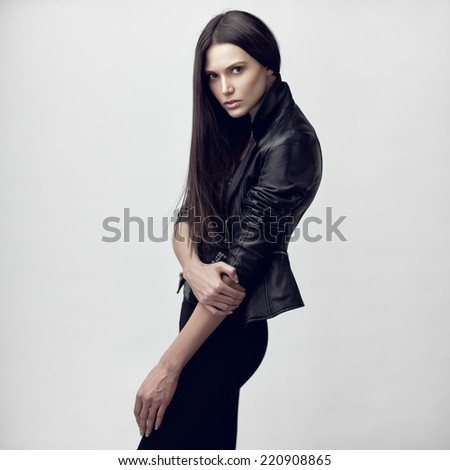 Fashion studio portrait of a young sensual model with long straight brown hair.