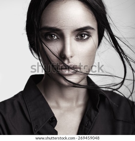 Closeup beauty portrait of a young sensual beautiful brunette girl with long black straight flying hair. Smoky eyes.