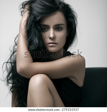 Fashion portrait of a young sensual beautiful brunette model with long black straight hair. Smoky eyes.