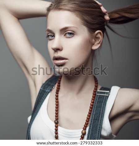 Beauty portrait of red-haired fit model with long straight hair in white tank top.