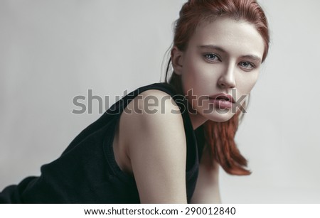 Beauty portrait of young beautiful red-haired model with long straight hair. Beautiful makeup.