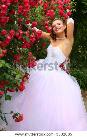 stock photo Smiling Girl in Wedding Dress in the red roses