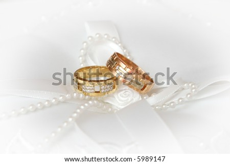 stock photo Wedding Rings on white silk and pearl