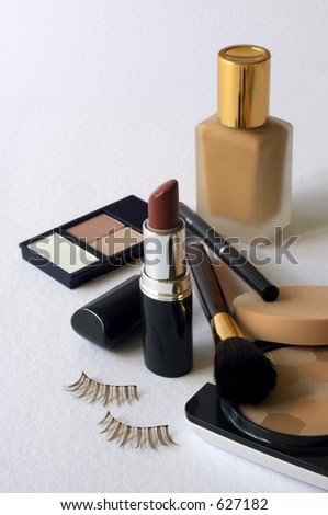 Assortment of women\'s cosmetics -  foundation, powder, lipstick, eyeshadow, lip liner, cheek brush & fake eyelashes