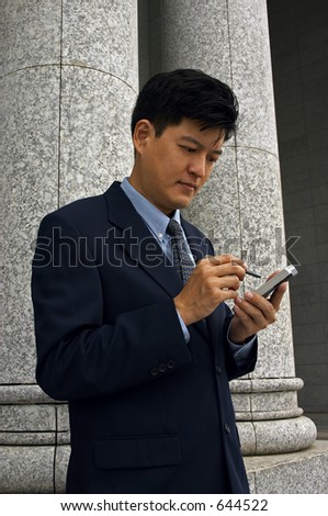 Asian Man In A Business Suit with A PDA (Vertical Format)