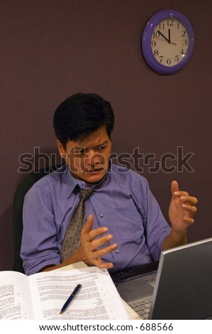 Computer Has Crashed! - A frustrated employee working late for a deadline shakes his hands in anger when his computer crashes. There is a slight motion-blur on his hands.