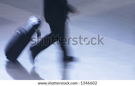 Businessman in suit with luggage walking hurriedly to catching his flight